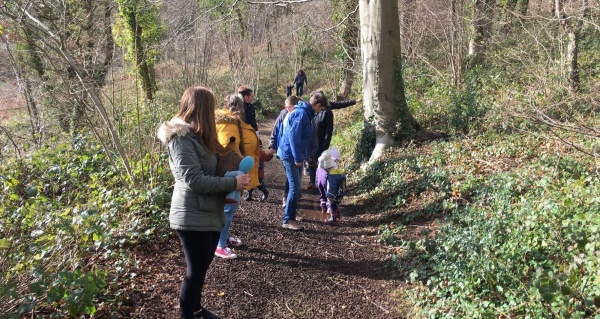 A group of adults and children on a woodland walk