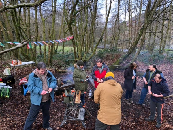 A group of people doing woodland crafts in a woodland