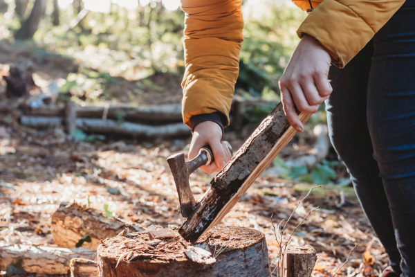 Person using a hand axe in a woodland
