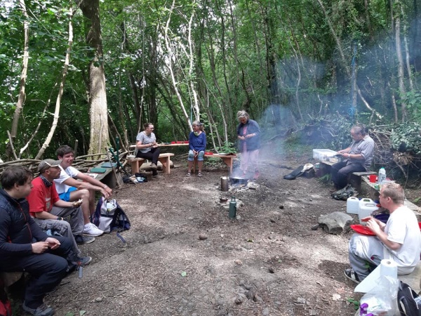 People sitting around a campfire in a woodland